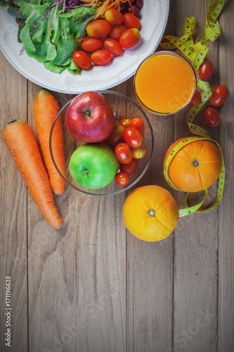 Fresh healthy salad with different fruits and vegetables on wooden background