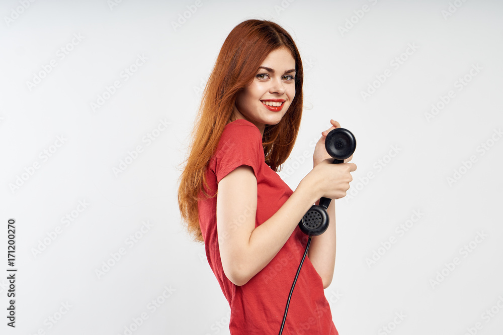 Obraz premium 1451330 woman in a red shirt holding a landline phone
