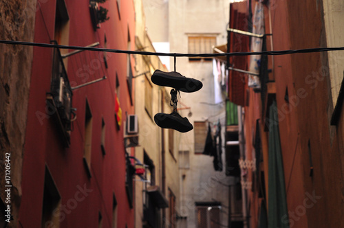 Hanging shoes between buildings