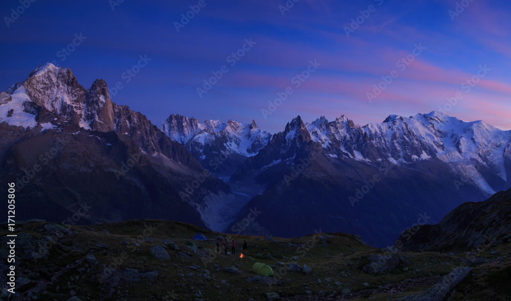 Campfire at a campsite in the mountains near Chamonix, France, during a colorful sunset.