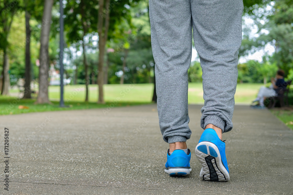 Closeup man walking in garden. Someone is exercising in the park. Closeup man walking in garden. Someone is exercising in the park.