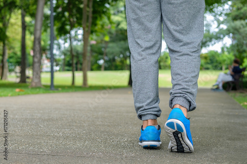Closeup man walking in garden. Someone is exercising in the park. 