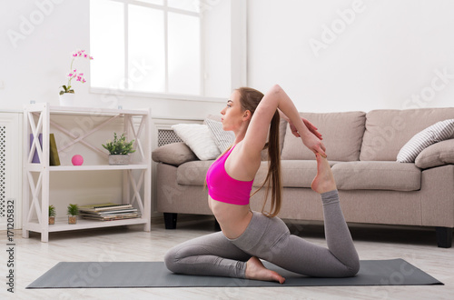 Woman training yoga in camel pose.