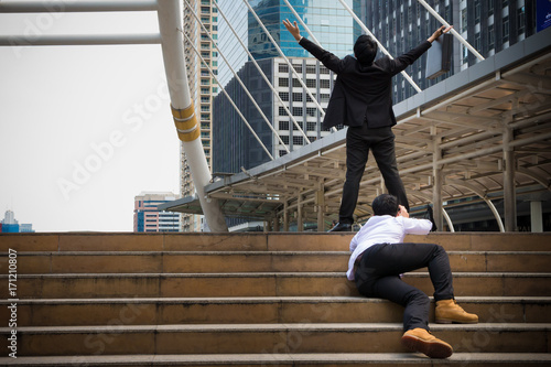 Turn on Asian businessman's who raising his two hands. Business people make a successful in his career and mission. He is a winner of the competition and the loser try to climb on the step to the goal photo