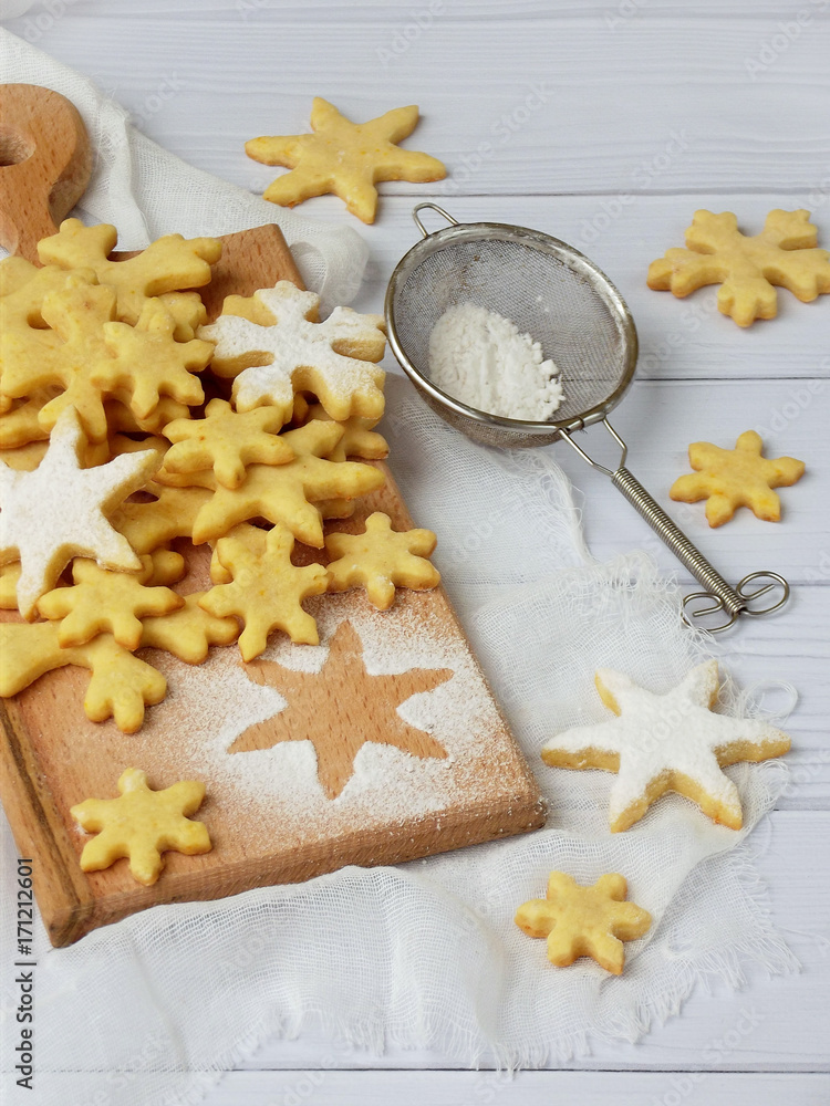 Christmas shortbread cookies in the form of snowflakes sprinkling sugar on white background Christmas shortbread cookies in the form of snowflakes sprinkling sugar on white background