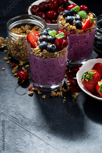 healthy blueberry with granola and fresh berries and dark background
