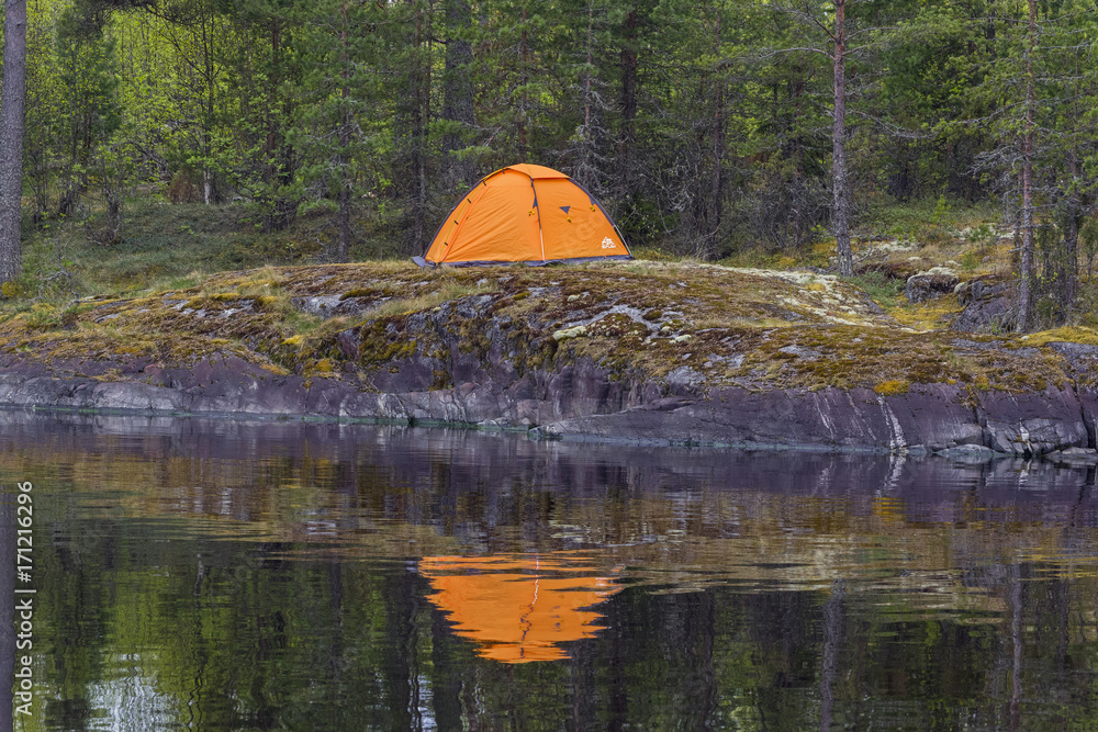 Tent on the shore and its reflection in the water.
