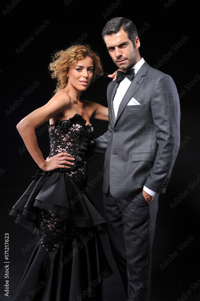 Young couple wear evening dress on black background