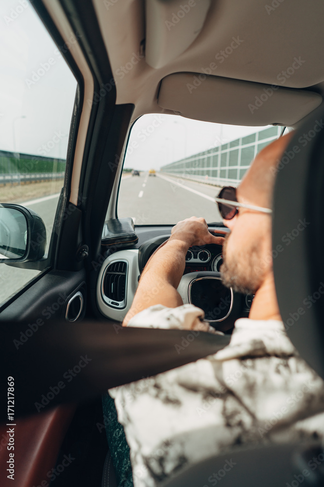 Naklejka premium The man in the car traveling on the road
