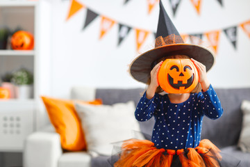 happy   child girl in witch costume to halloween