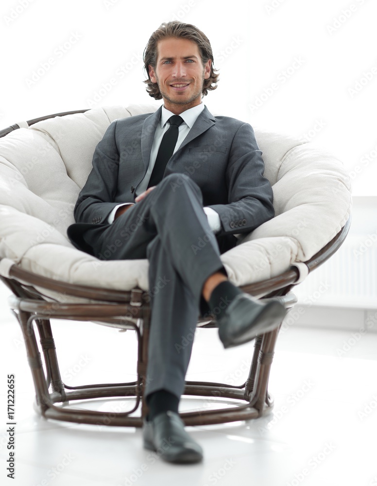 confident businessman sitting in a large comfortable chair. confident businessman sitting in a large comfortable chair.