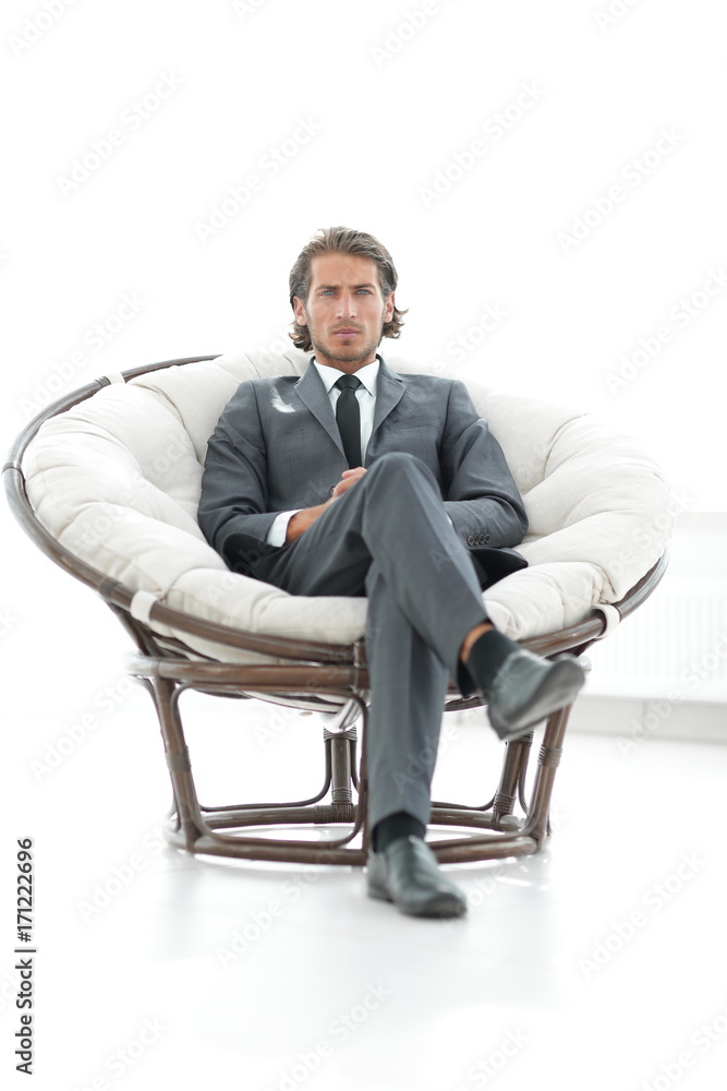 confident businessman sitting in a large comfortable chair. confident businessman sitting in a large comfortable chair.