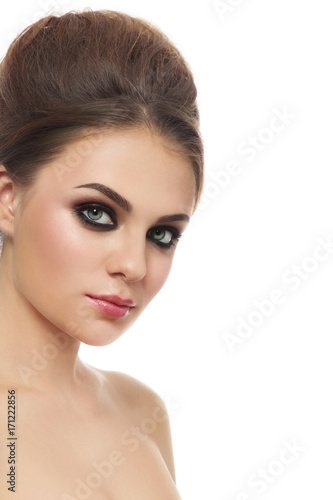 Portrait of young beautiful woman with smoky eyes and hair bun over white background, copy space