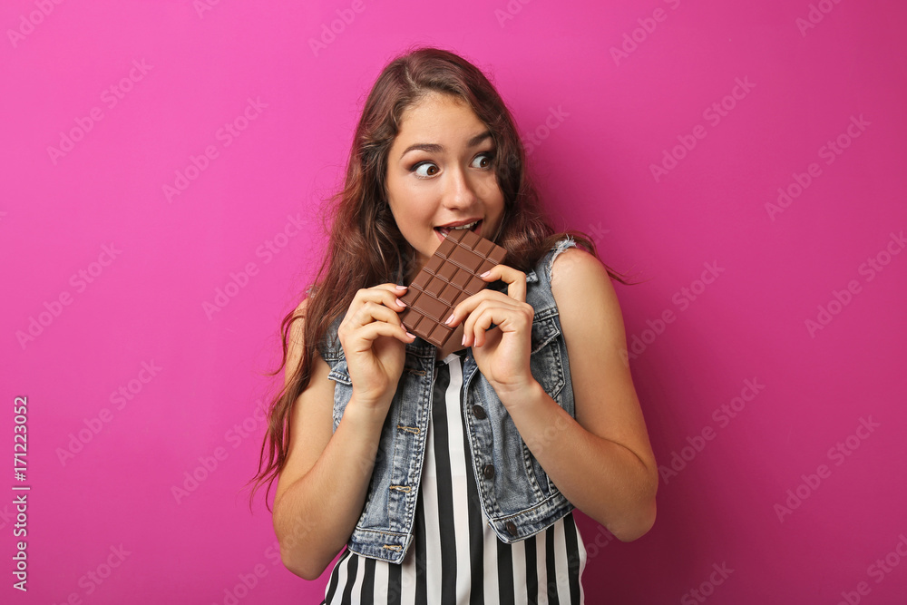Portrait of young woman with chocolate bar on pink background Portrait of young woman with chocolate bar on pink background