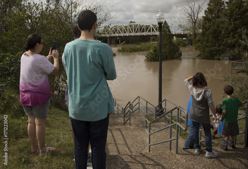 Family looking down steps taking photos of flooded town