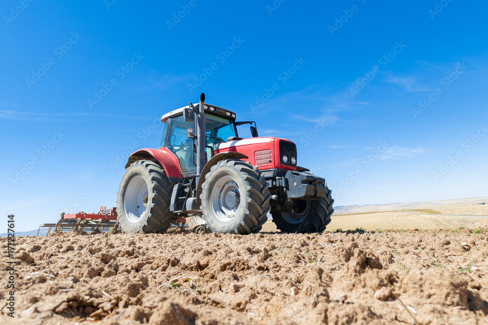 agricultural tractor in the foreground with blue sky background. agricultural tractor in the foreground with blue sky background.