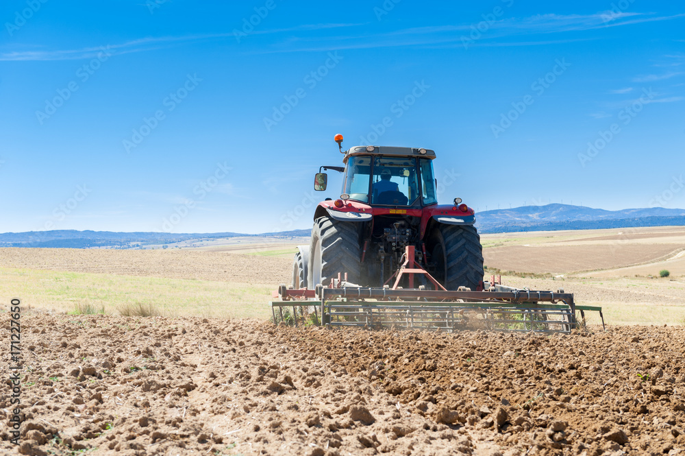 Fototapeta premium agricultural tractor in the foreground with blue sky background.