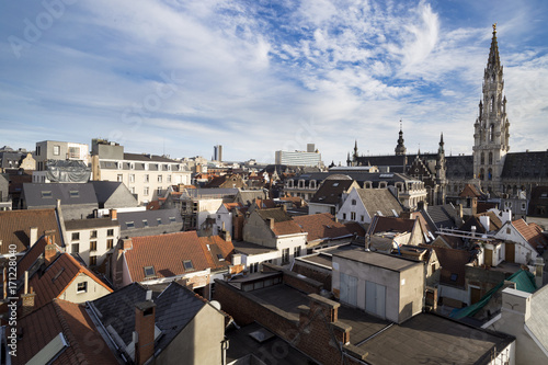 Aerial view at Brussels Town Hall tower and old town tiled roofs, Brussels, Belgium. Top view at roofs, Brussels City Town Hall and blue sky with clouds