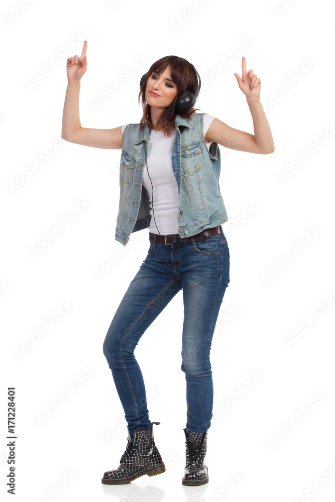 Young Rock Girl In Headphones Is Dancing And Pointing Up Young Rock Girl In Headphones Is Dancing And Pointing Up