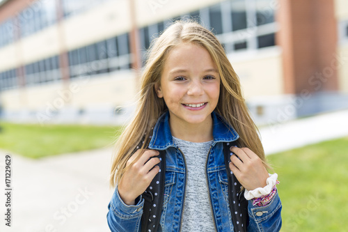 Great Portrait Of School Pupil Outside Classroom Carrying Bags photo