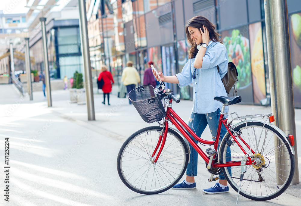 Beautiful young woman with bicycle in urban environment. Beautiful young woman with bicycle in urban environment.