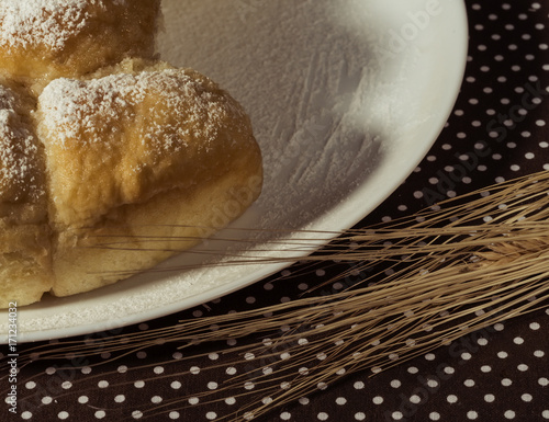 Cake on a white plate and wheat ears near photo