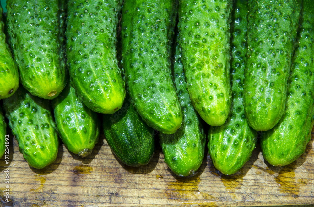 Wet cucumbers are tiered on a board.
Wet cucumbers are tiered on a board.