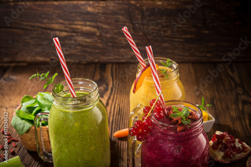 Healthy fresh smoothies with ingredients on old wooden table.