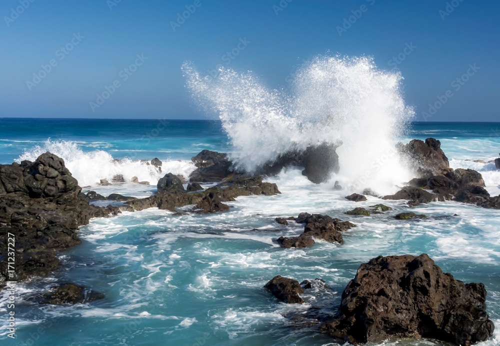 Ocean waves crashing against rocks at Hawaii beach