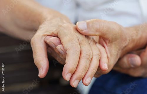 Fototapeta Naklejka Na Ścianę i Meble -  Elderly couple holding hands. Love, tenderness, togetherness, trust, support concept.