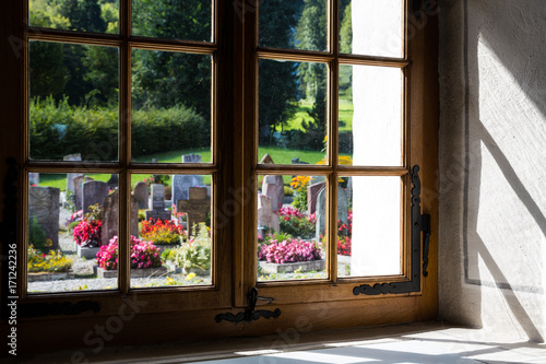 Obraz na plátně Graveyard through the church window in Blumenstein Switzerland