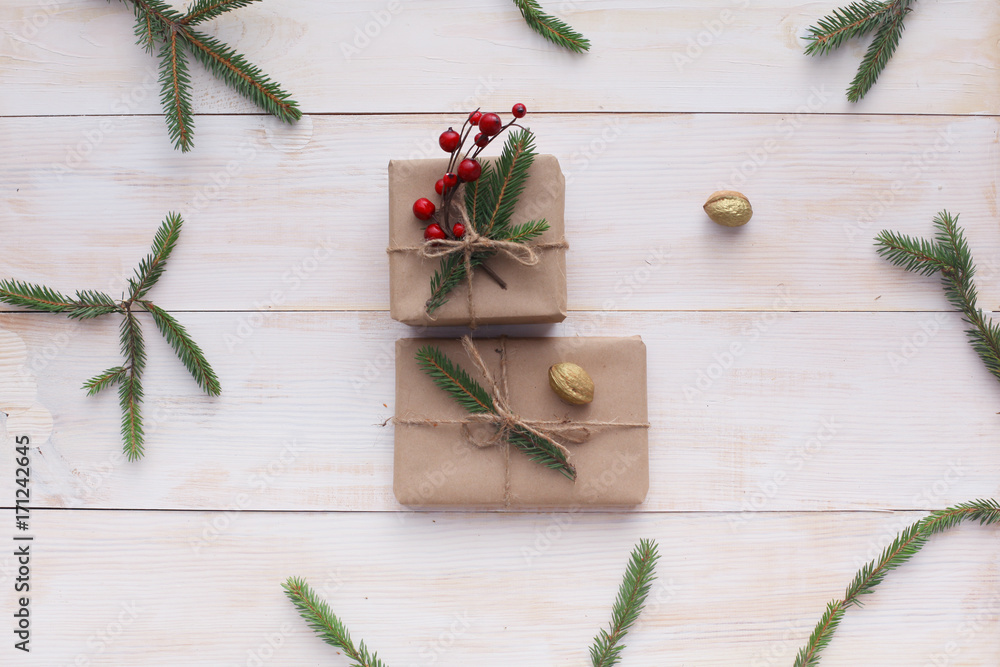 Christmas gift boxes and fir tree branch on wooden table, flat lay