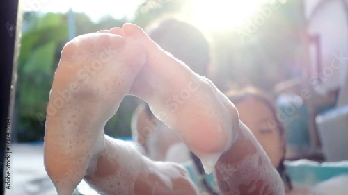 Close-up of foot girl and lie in the bathtub in outdoor. Concept happy family vacations. Slowmotion shot. photo