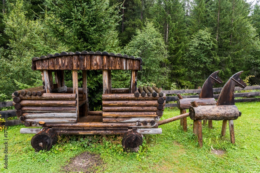 Wooden carriage and horses in a forest