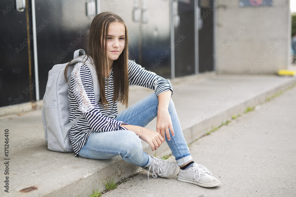 Fototapeta premium Elementary school pupil outside carrying rucksack