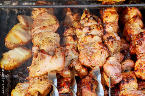 The smoke rises over the fried meat on the skewers on the coals.