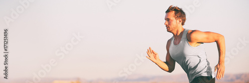 Fitness athlete runner man running on sunset sky background. Jogging active lifestyle concept. photo