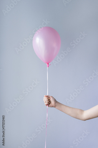 hand holding single pink balloon