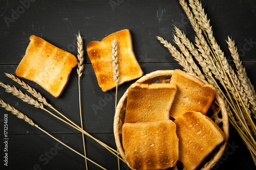Toast the bread on a black wooden background photo