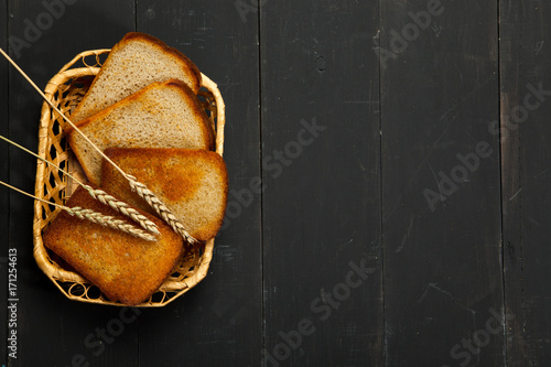 Toast the bread on a black wooden background photo