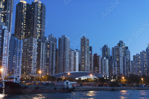 High rise residential buildings and harbor of Hong Kong city at dusk