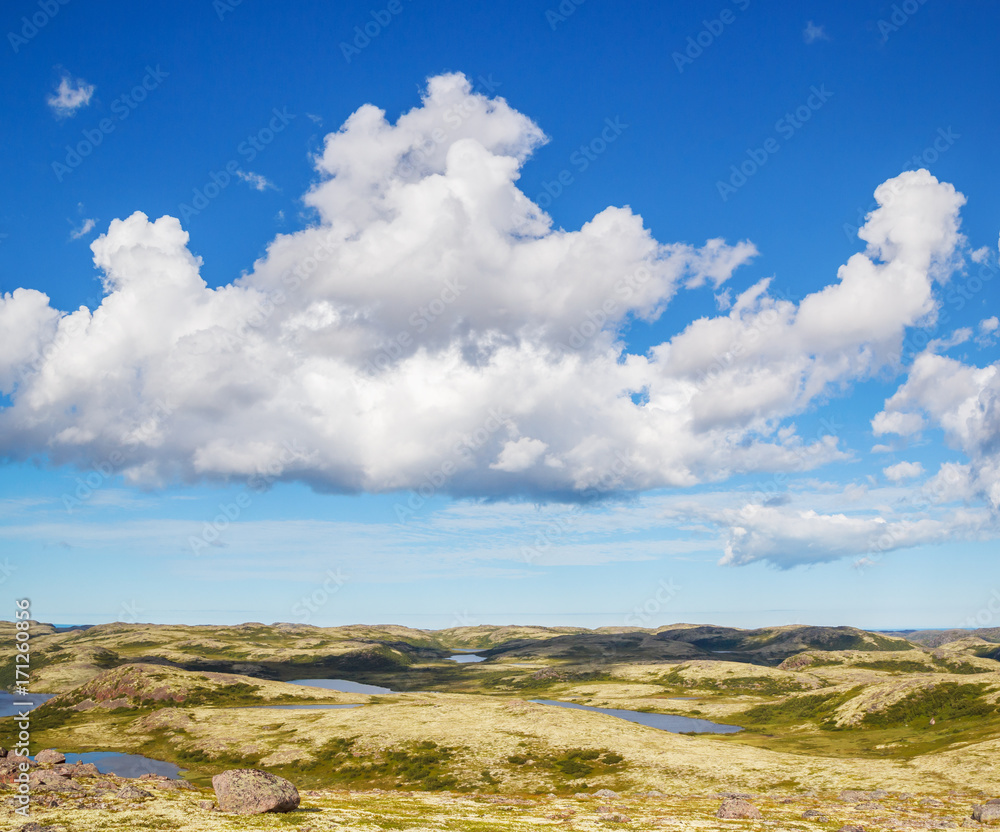 View of hills, lakes and clouds in the sky in the tundra in summer