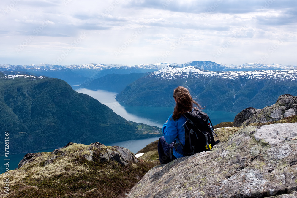 female hiker enjoys view over fjord in Norway