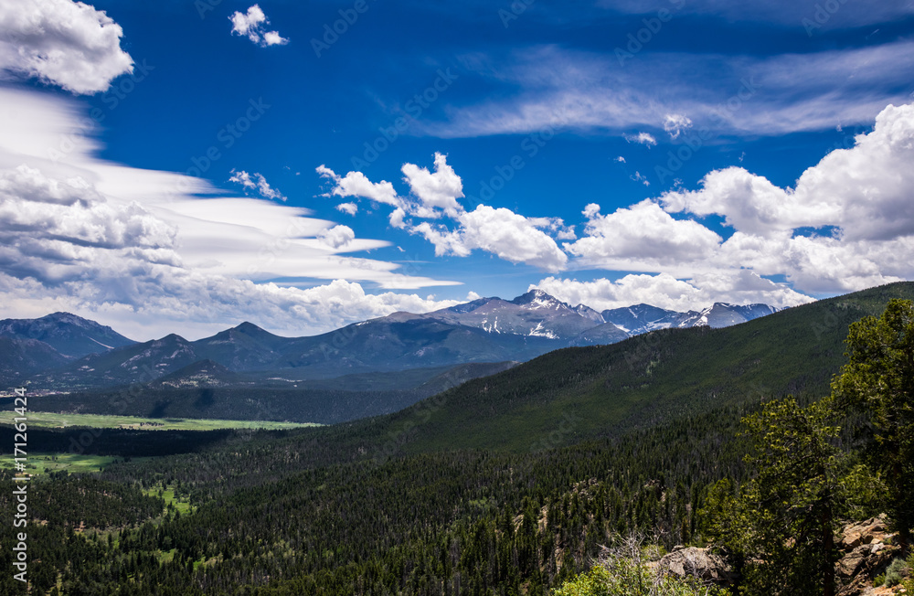 Mountain ridge of the Rocky Mountains against the background of a cloudy blue sky. Rocky Mountain National Park