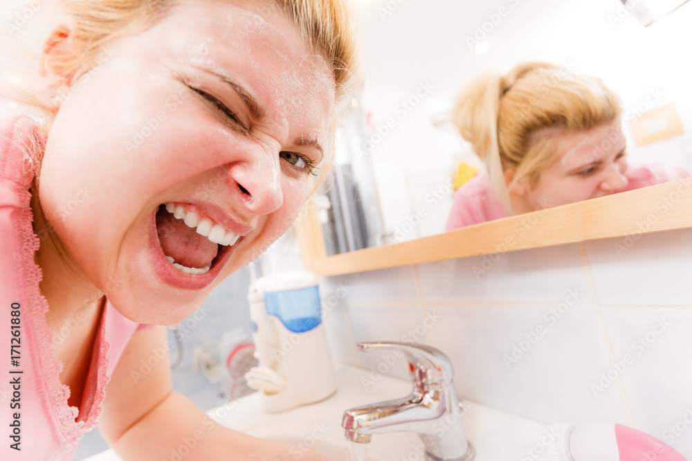 Happy woman washing her face under sink Happy woman washing her face under sink
