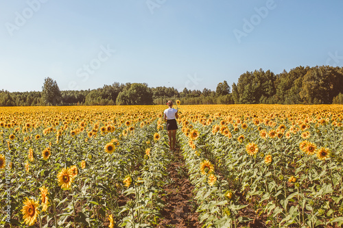 Beautiful stylish hippie girl on the sunflower field