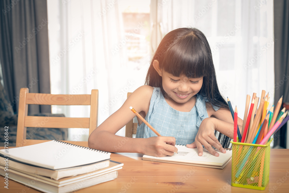Child girl drawing on the table in the house Child girl drawing on the table in the house