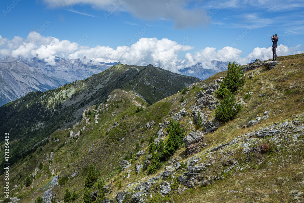 une jeune femme sur le haut d'une colline devant un paysage alpin une jeune femme sur le haut d'une colline devant un paysage alpin