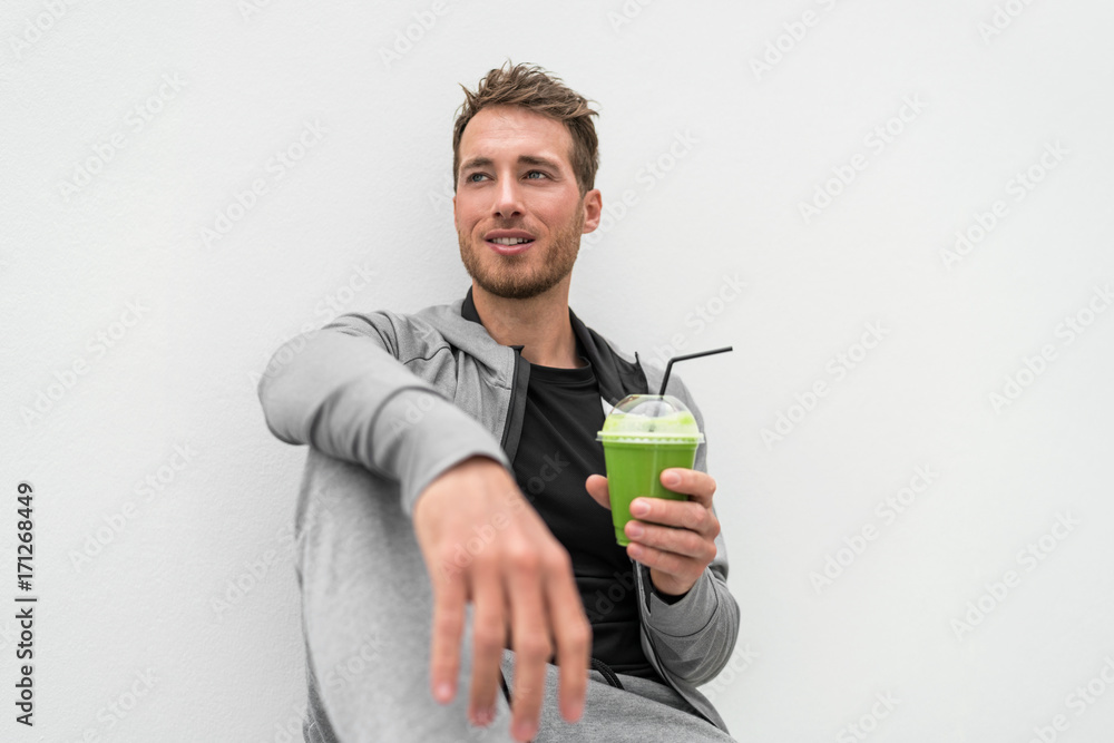 Healthy man drinking green smoothie spinach juice at home relaxing. Young adult eating detox diet, active lifestyle. Healthy man drinking green smoothie spinach juice at home relaxing. Young adult eating detox diet, active lifestyle.