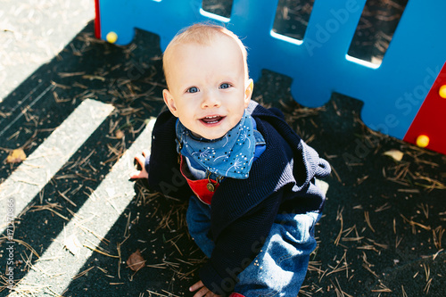 Portrait of a cute child boy with blue eyes, who is starring at the camera and smile.Outdoors healthy child activity, active lifestyle and having fun on family summer vacation with son at the playgrou